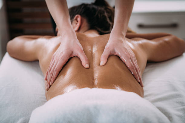 A woman lying down while receiving a relaxing back massage