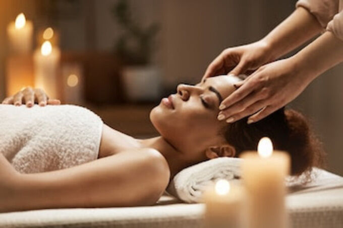 Woman receiving a head massage from a professional massage therapist while lying down